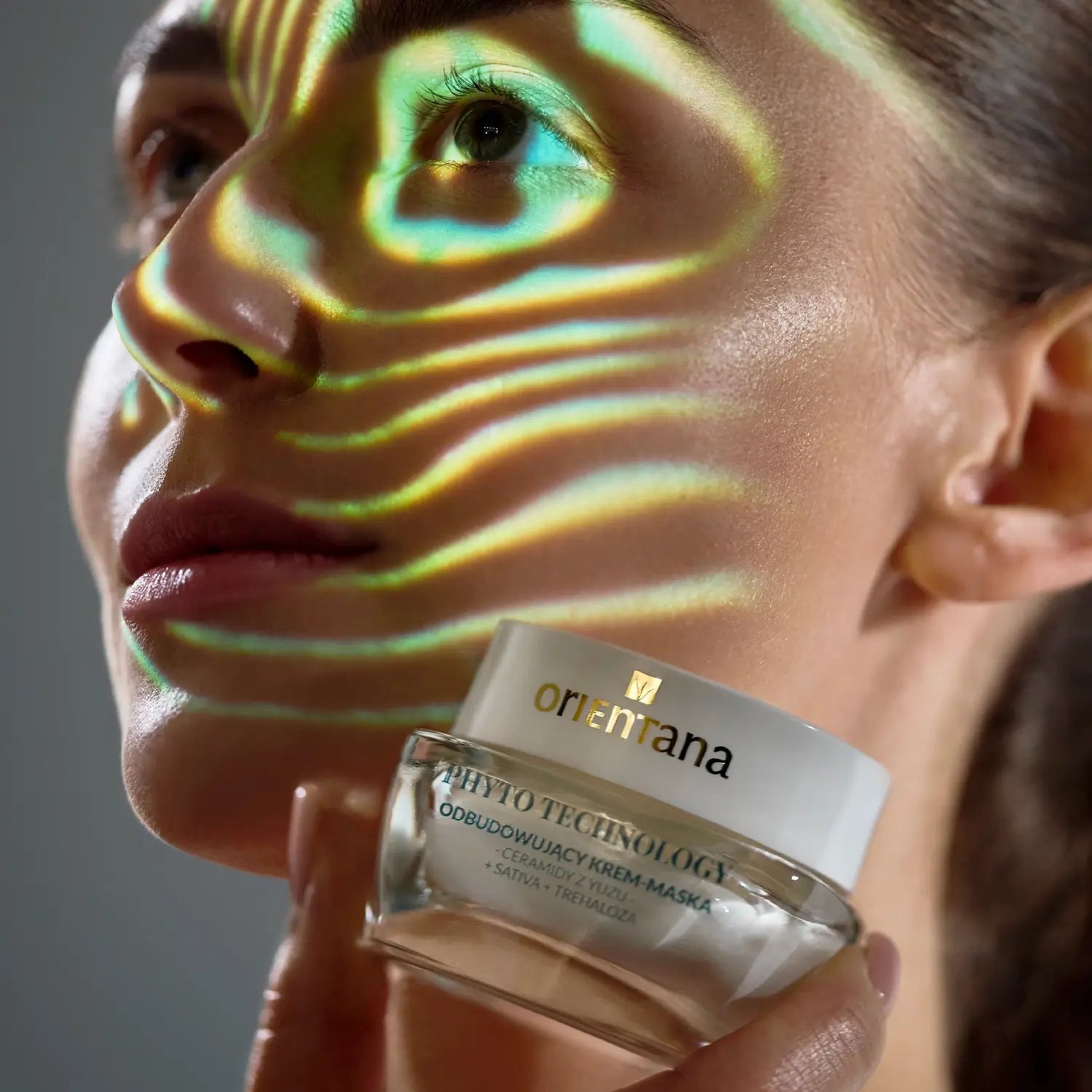 Kobieta trzymająca odbudowującą krem-maskę z ceramidami Yuzu Orientana Phyto Technology – kosmetyk regenerujący barierę hydrolipidową i poprawiający elastyczność skóry.