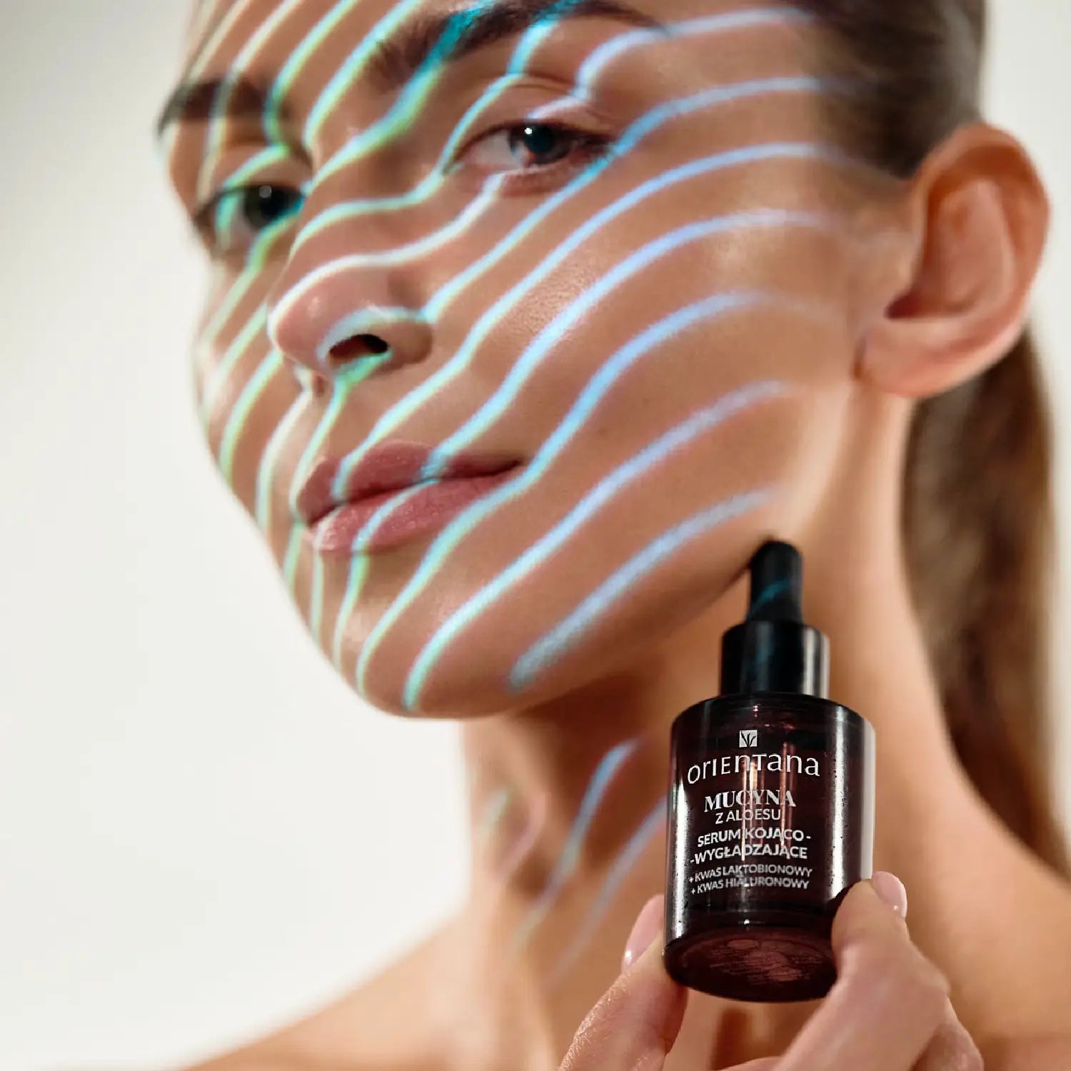 Kobieta trzymająca serum Mucyna z Aloesu Orientana – kojące serum wygładzające wspierające regenerację skóry, nawilżenie i redukcję podrażnień.